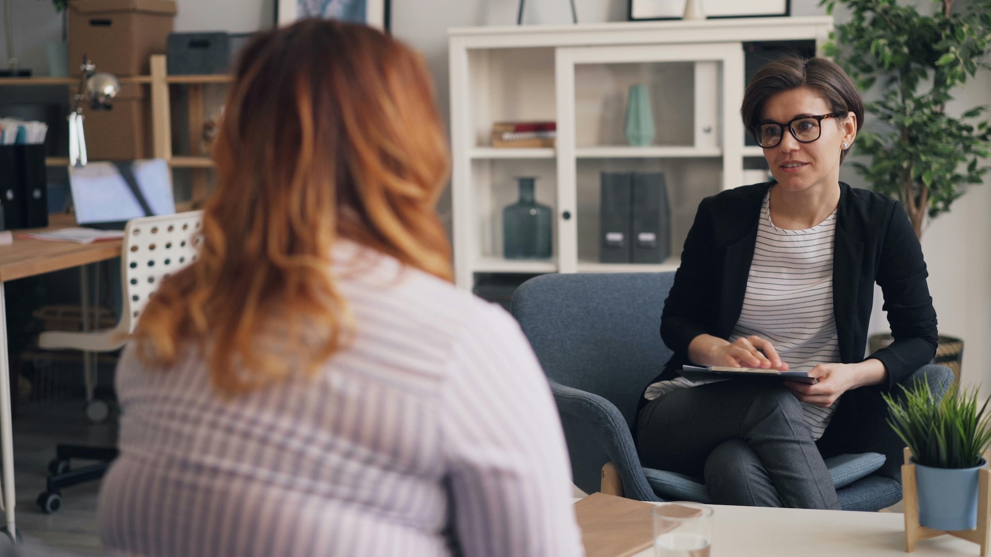 A plus-size woman talking with a counselor